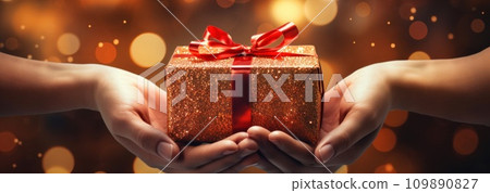 person hands out a gold gift inside of christmas tree lights person hands out a gold gift inside of christmas tree lights 109890827