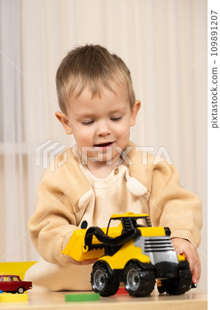 Little cute boy playing with toys while sitting at table 109891207
