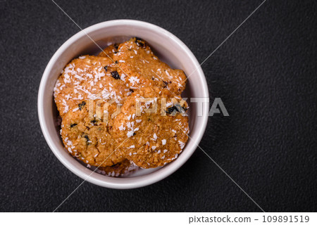 Delicious sweet round sponge cookies sprinkled with coconut flakes Delicious sweet round sponge cookies sprinkled with coconut flakes 109891519