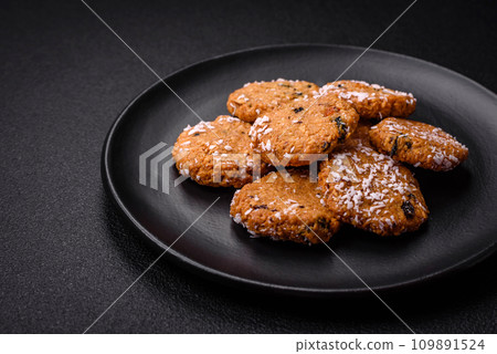 Delicious sweet round sponge cookies sprinkled with coconut flakes Delicious sweet round sponge cookies sprinkled with coconut flakes 109891524