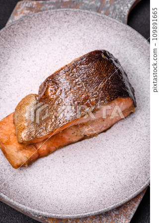 Fresh cooked delicious salmon steak with spices and herbs baked on a grill Fresh cooked delicious salmon steak with spices and herbs baked on a grill 109891665