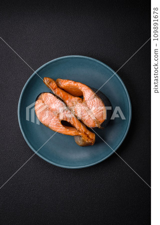 Fresh cooked delicious salmon steak with spices and herbs baked on a grill 109891678