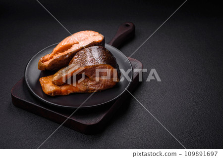 Fresh cooked delicious salmon steak with spices and herbs baked on a grill Fresh cooked delicious salmon steak with spices and herbs baked on a grill 109891697