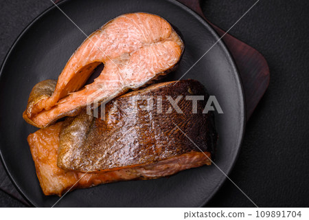 Fresh cooked delicious salmon steak with spices and herbs baked on a grill 109891704