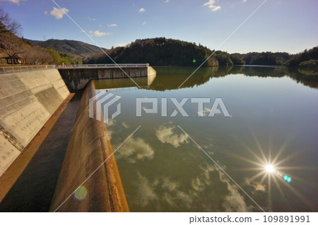 陽光反射在洩洪調節池溢洪道和湖面上 109891991