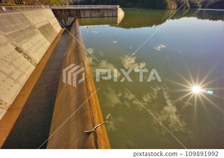陽光反射在洩洪調節池溢洪道和湖面上 109891992