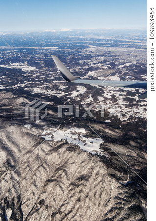 Winter snowy mountains seen from the sky (Aomori Prefecture) 109893453