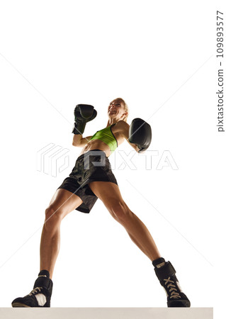 Bottom view of muscular young woman, boxing athlete in motion, training, punching isolated over white background. Sport, healthy and active lifestyle 109893577