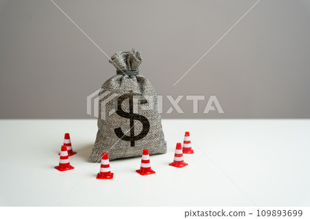 Dollar money bag blocked by road cones. Freezing of accounts and sanctions on capital. Dedollarisation. Suspicious funds with unknown sources. National money reserve. 109893699