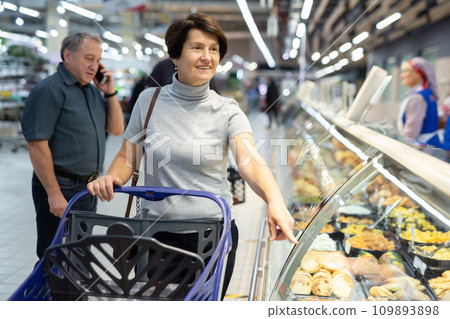 Couple of spouses buy ready-made meals in culinary department 109893898