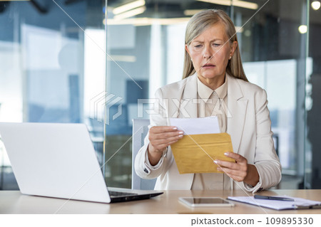 Businesswoman boss received letter mail notification message with bad news, upset and sad senior woman reading news data , female worker inside office at workplace. Businesswoman boss received letter mail notification message with bad news, upset and sad senior woman reading news data , female worker inside office at workplace. 109895330