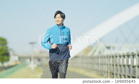 young man jogging on the bank young man jogging on the bank 109895645
