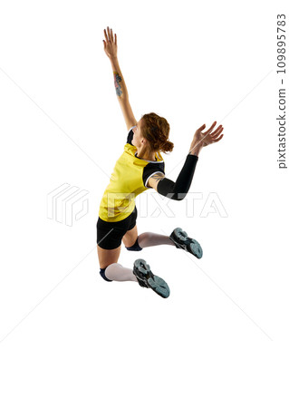 Young woman, professional volleyball player in yellow black uniform training, hitting ball in a jump isolated over white background. Sport, active lifestyle Young woman, professional volleyball player in yellow black uniform training, hitting ball in a jump isolated over white background. Sport, active lifestyle 109895783
