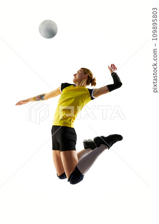 Full-length image of young athletic woman, volleyball player in motion, playing and hitting ball isolated over white background. Sport, active and healthy lifestyle 109895803