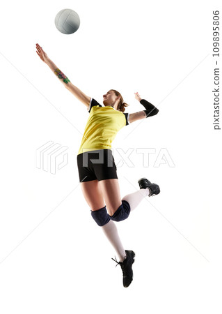 Full-length dynamic image of young woman, volleyball player in motion, practicing, hitting ball in a jump isolated over white background. Sport, active and healthy lifestyle 109895806
