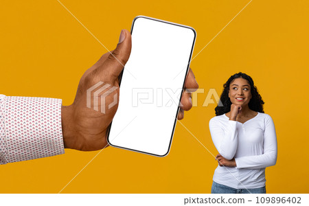 Interested Black Female Looking At Blank Smartphone In Huge Hand 109896402