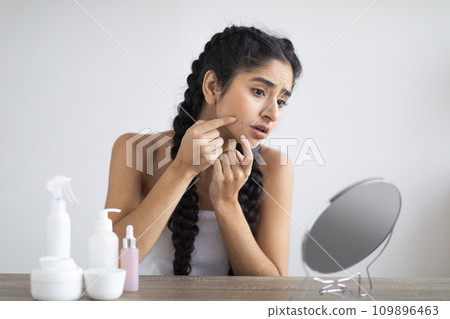 Skin Problems. Upset Young Indian Woman Looking At Pimple On Her Cheek Skin Problems. Upset Young Indian Woman Looking At Pimple On Her Cheek 109896463