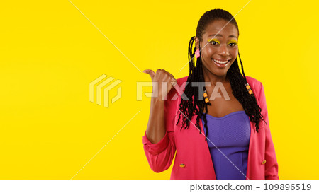 Black Female Pointing Thumb Aside At Blank Space, Studio Shot 109896519