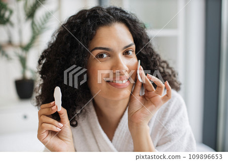 Healthy young multiracial woman holding cotton cosmetic sponges Healthy young multiracial woman holding cotton cosmetic sponges 109896653