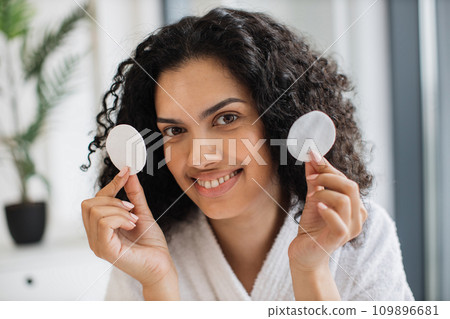 Close-up portrait of positive curly haired multinational woman in bathrobe 109896681