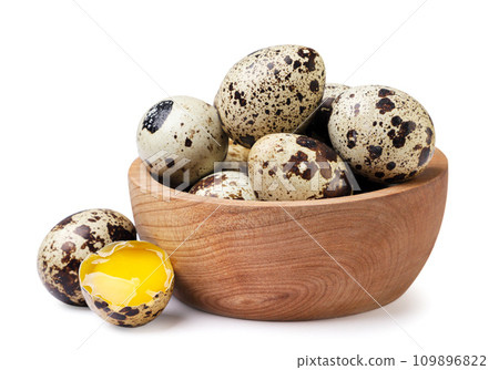 Quail eggs in a wooden plate and broken on a white background. Isolated 109896822