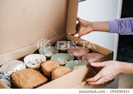 Assorted Buffet Snacks Ready for Catering Service. Selection of assorted snacks presented in small bowls, packaged in a box, prepared for easy distribution at a catering or buffet event. 109896931