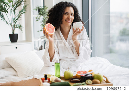 African woman holding half of grapefruit making homemade cream for healthy skin 109897242