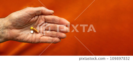 Man old hand holds pills, close-up, selective focus. Banner, copy space Man old hand holds pills, close-up, selective focus. Banner, copy space 109897832
