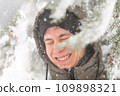 a boy is playing with snow on the street, it is snowing, a blizzard and frost on a winter day 109898321