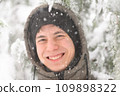 a boy is playing with snow on the street, it is snowing, a blizzard and frost on a winter day 109898322
