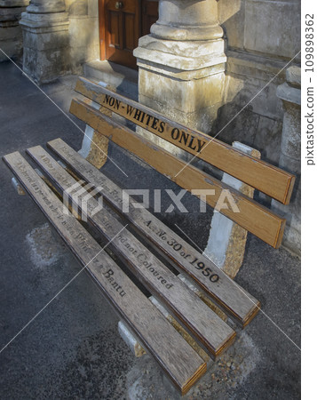 Reminder of the segregation policy with latin inscription on NON-WHITES ONLY bench in Cape Town. 109898362