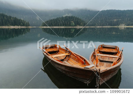 Two Rowboats on Morning Mountain Lake with Mist 109901672