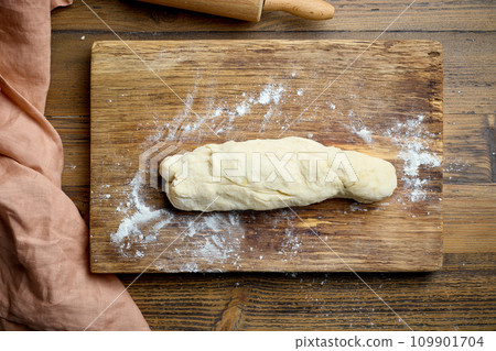 dough on wooden cutting board dough on wooden cutting board 109901704