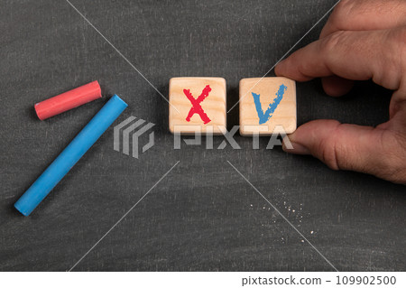 Right and wrong on wooden cubes. Black scratched textured chalkboard background 109902500