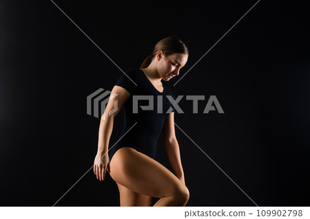 Beautiful ballet dancer sport aerobics female posing on white and black studio background 109902798