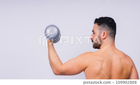 Athletic man doing exercises with dumbbell at biceps on white background. Strength and motivation 109902808