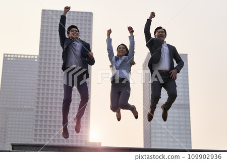 three asian business people jumping and celebrating success outdoors 109902936