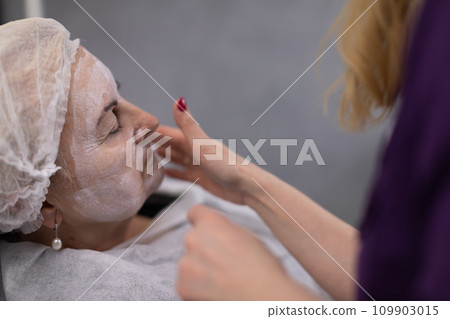 An elderly woman relaxes in a beauty salon. 109903015