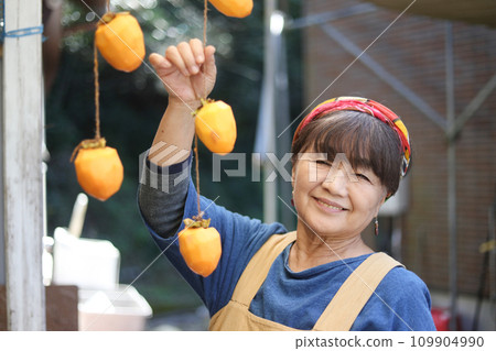 A woman drying persimmons A woman drying persimmons 109904990