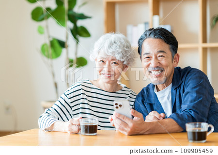 一對年長夫婦一起看他們的智慧型手機。 109905459