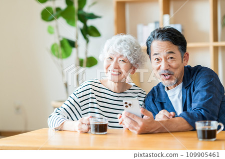 一對年長夫婦一起看他們的智慧型手機。 109905461