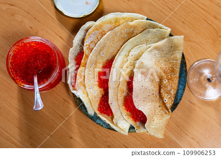 Appetizing pancakes with red caviar. Russian kitchen closeup 109906253