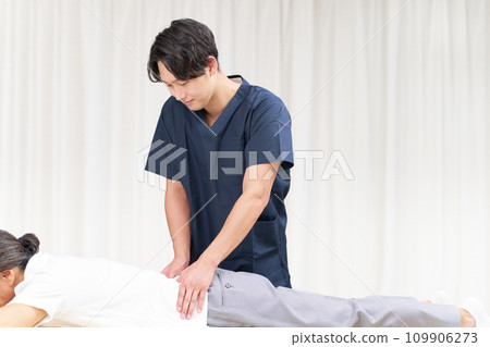Young male chiropractor performing treatment 109906273