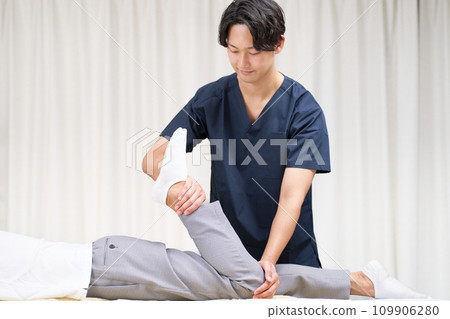 Young male chiropractor performing treatment Young male chiropractor performing treatment 109906280