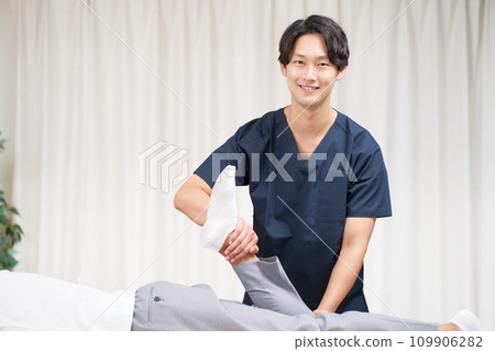 Young male masseuse performing treatment Young male masseuse performing treatment 109906282