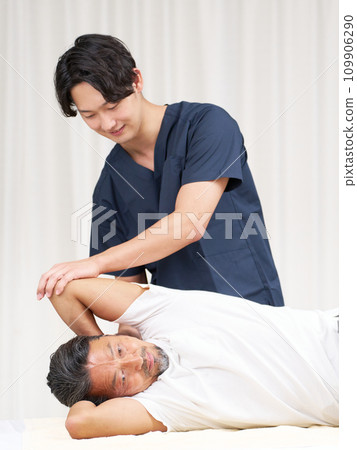 A young chiropractor performing a treatment on a man A young chiropractor performing a treatment on a man 109906290