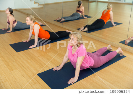 Ladies are doing upward-facing dog pose 109906334