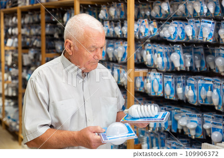 Elderly male buyer selecting light bulbs 109906372