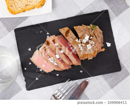 Fried veal steak served on black service board on the table 109906411