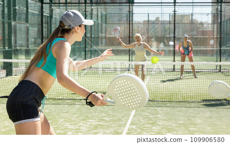 Young woman playing Padel Tennis in pairs in tennis court 109906580